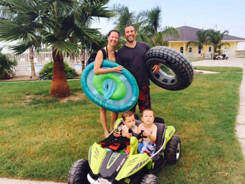 Family with pool floats on the lawn at Drifters RV Resort