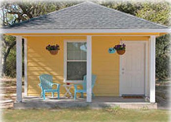 Yellow cottage with a front porch at Drifters RV Resort